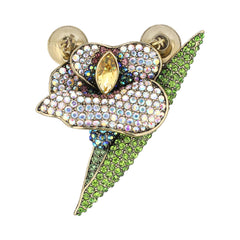 A gold-tone calla lily brooch featuring a central yellow marquise crystal, a white petal covered in iridescent rhinestones, and a green leaf-shaped setting paved with green crystals, shown on a plain white background.