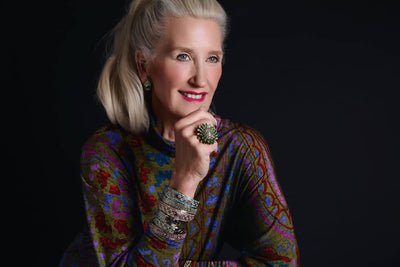 Woman wearing a colorful patterned top against a black background