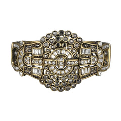 Decorative bracelet with gold, black, and clear gemstones on a white background