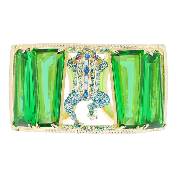 Decorative brooch with green gemstones and a central design on a white background
