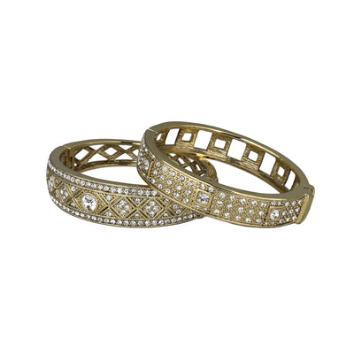 Two gold bangles with diamond-like stones on a white background. daily double bracelet set by heidi daus