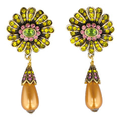 Pair of ornate earrings with gemstones and a pearl drop on a white background