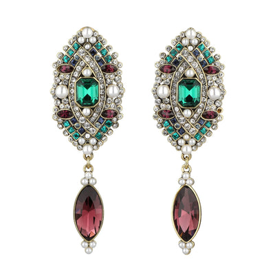 Pair of ornate earrings with gemstones on a white background