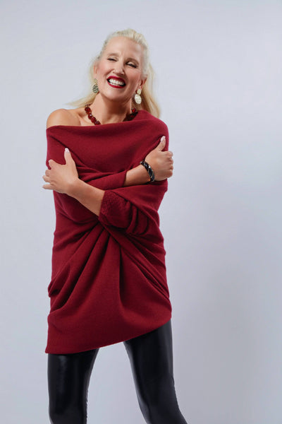 Woman wearing a red off-shoulder dress against a plain background