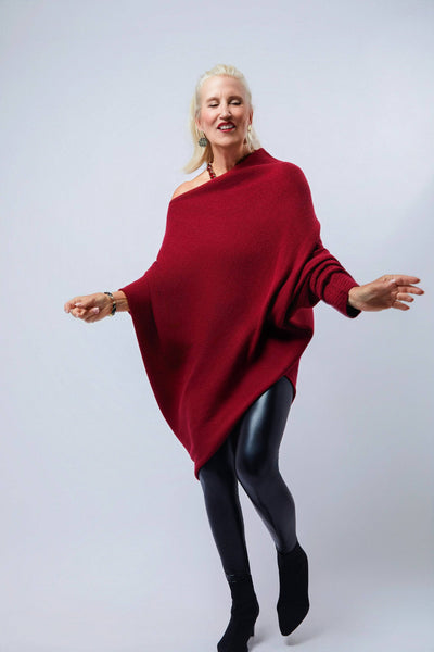 Person wearing a red poncho and black tights on a white background