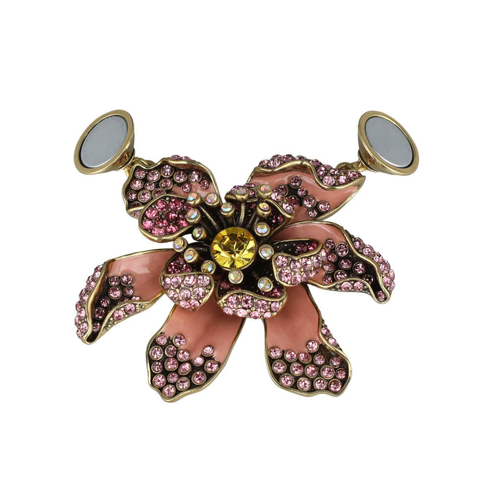 Decorative brooch with pink gemstones and a yellow center on a white background