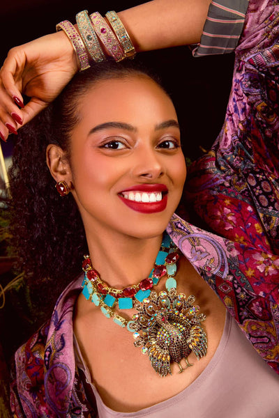 Woman wearing colorful jewelry with a patterned background