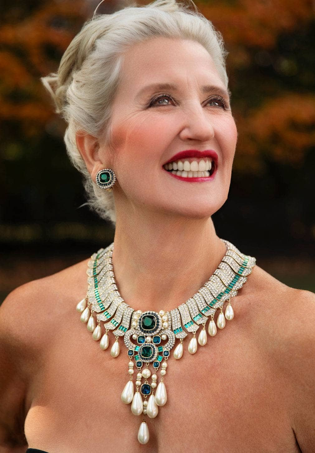 Woman wearing a luxurious necklace with a blurred natural background