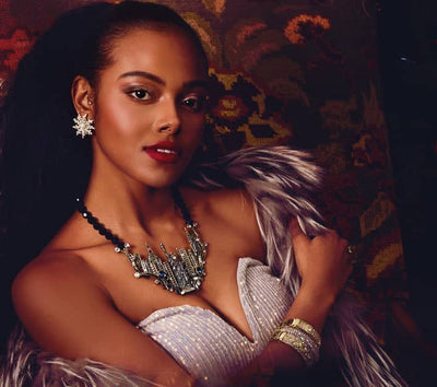 Woman in a glamorous outfit with a fireplace in the background