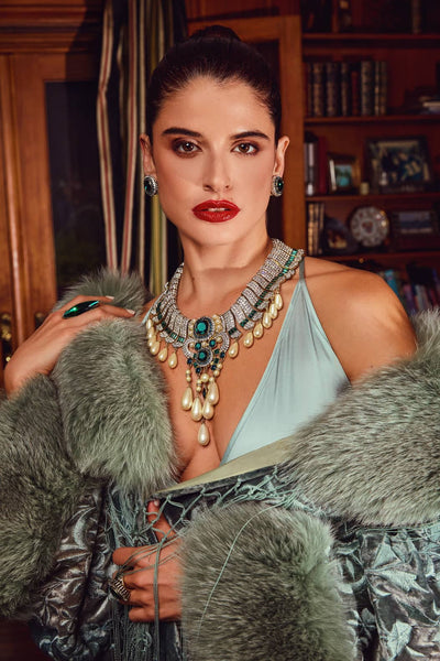Woman wearing a luxurious necklace with gemstones in an indoor setting