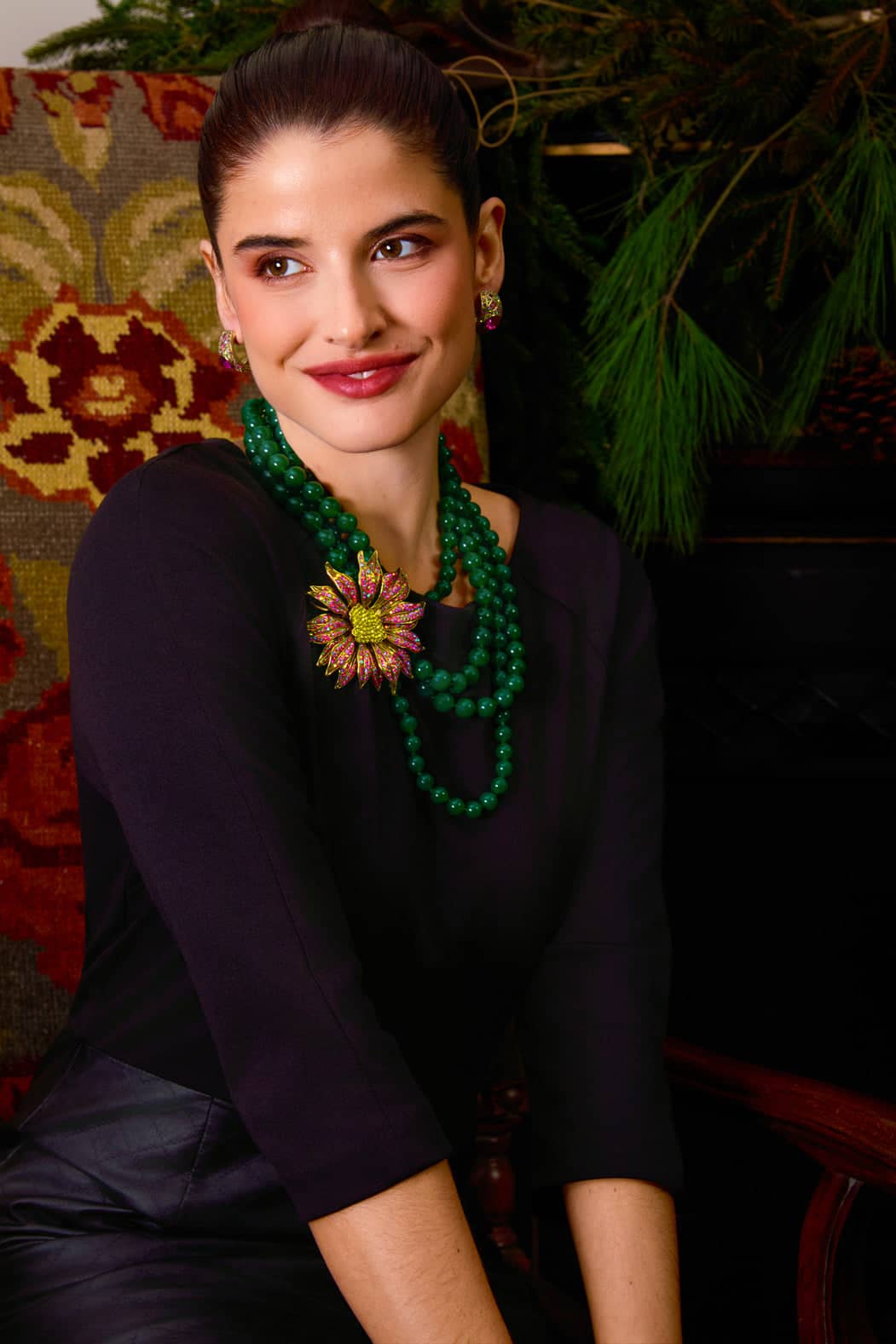 Woman wearing a green necklace with a floral pendant in a decorative setting