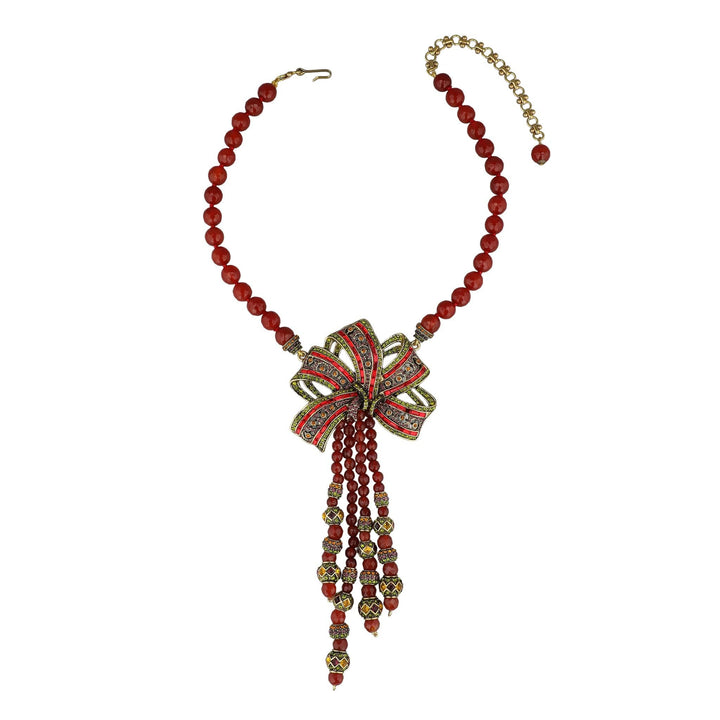 Necklace with red beads and a decorative bow on a white background