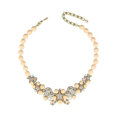 Necklace with beige beads and decorative elements on a white background