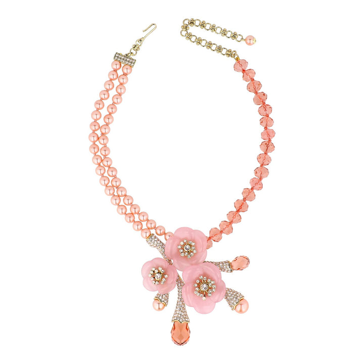 Necklace with pink floral pendant and beads on a white background