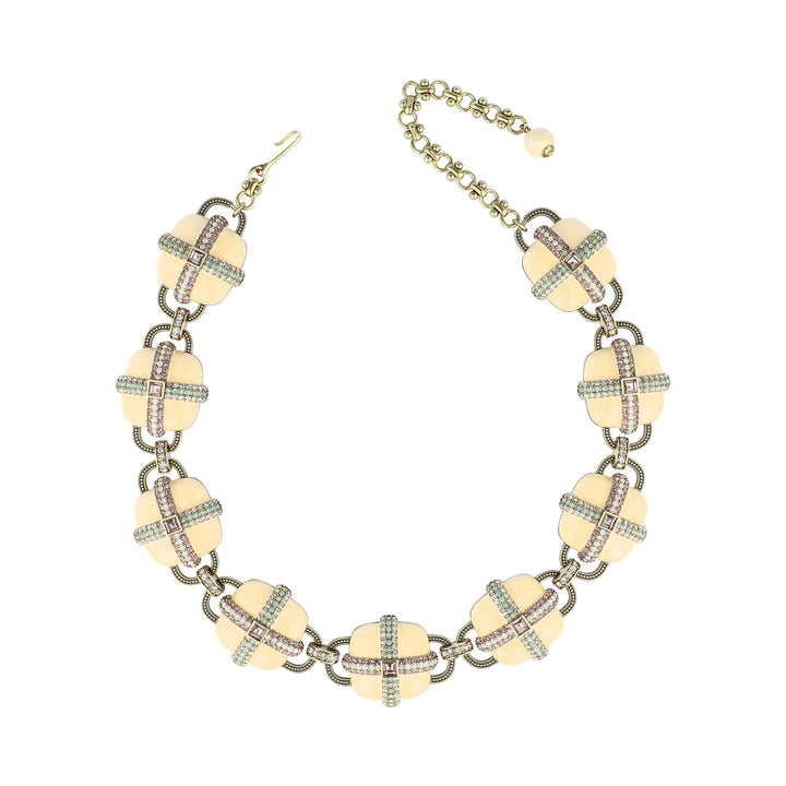 A vintage-style statement necklace featuring cream-colored clover motifs linked by gold-toned chains with small pink and green rhinestone accents, shown on a plain white background.