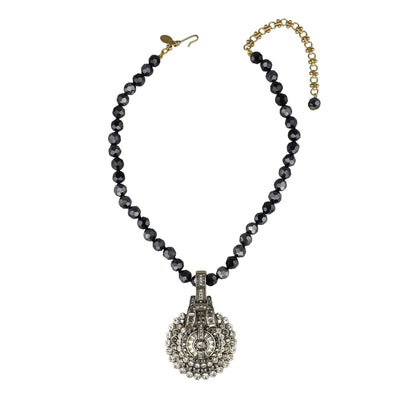 Necklace with black beads and a decorative clasp on a white background