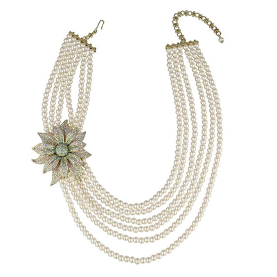 Multi-layered pearl necklace with a decorative flower pendant on a white background