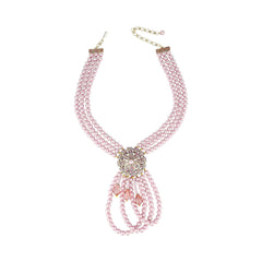 A pink pearl multi-strand necklace with a central rhinestone brooch and dangling pink crystal accents, displayed on a clean white background.