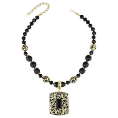 A black beaded necklace with gold filigree accents and a rectangular pendant featuring a black rose motif, displayed on a clean white background.