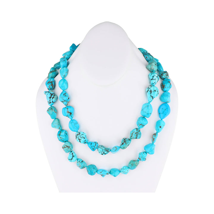 Turquoise necklace on a white mannequin bust against a white background