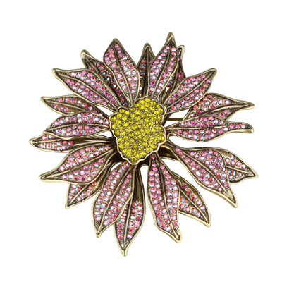 Decorative brooch with pink gemstones and a yellow center on a white background