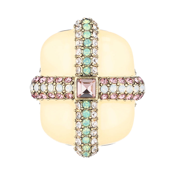 A gold-plated cross-shaped ring with a central square pink gemstone, flanked by rows of light green and clear rhinestones on the vertical arms, and pink and clear rhinestones on the horizontal arms, set against a plain white background.