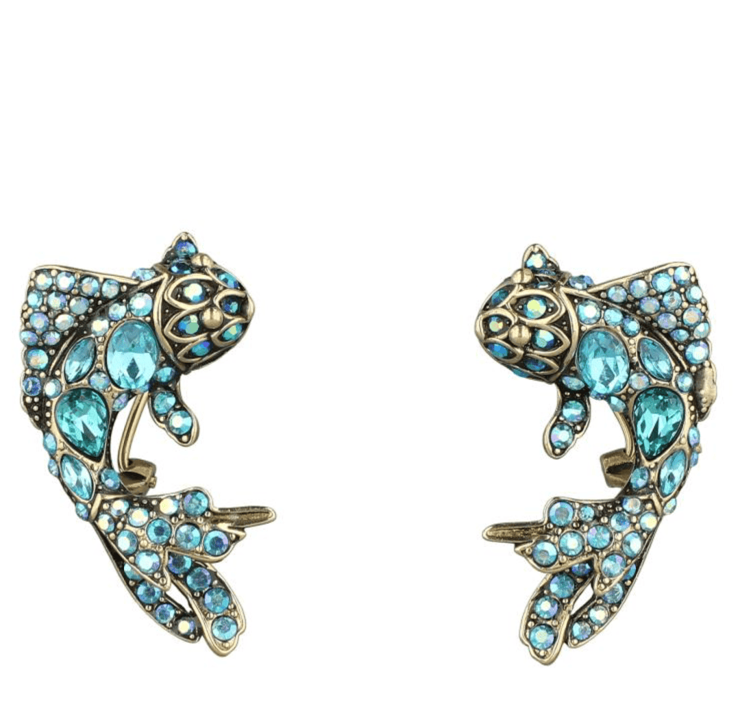 Pair of fish-shaped earrings with turquoise gemstones on a white background