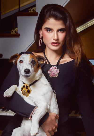 Woman holding a dog wearing paw print bcooch